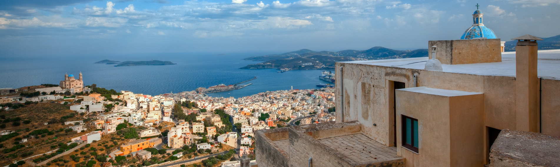 Panorama di Syros con vista sulle abitazioni, sul golfo e delle altre isole delle Cicaldi all'orizzonte
