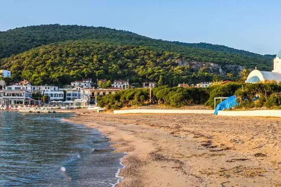 Panorama di una spiaggia dell'isola di Agistri con sullo sfondo una chiesa